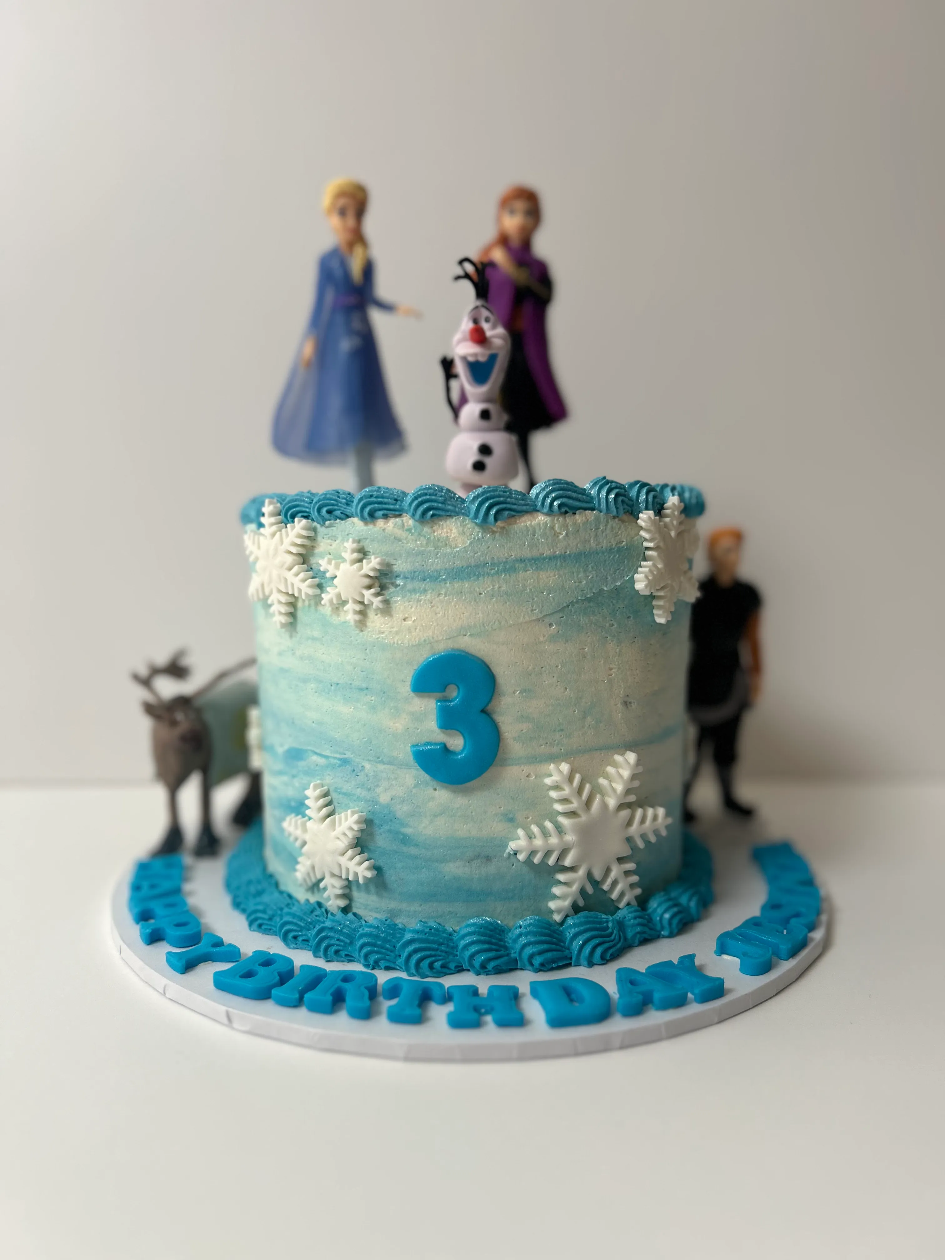 A 'Frozen'-themed blue and white birthday cake